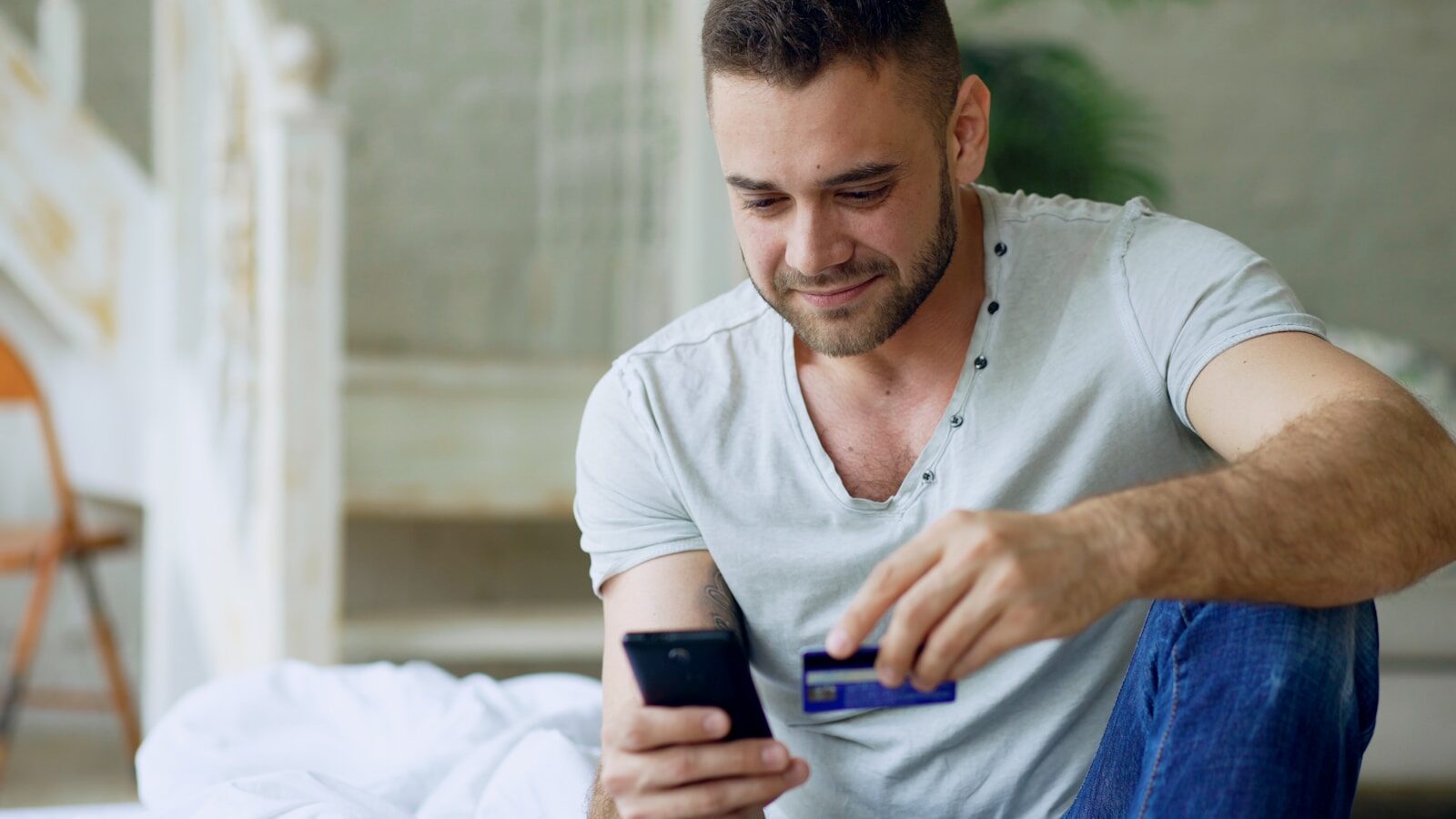 Man using phone and credit card for online shopping